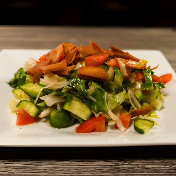 A vibrant Lebanese Fattoush salad with crisp lettuce, tomatoes, cucumbers, onions, and fried pita bread.